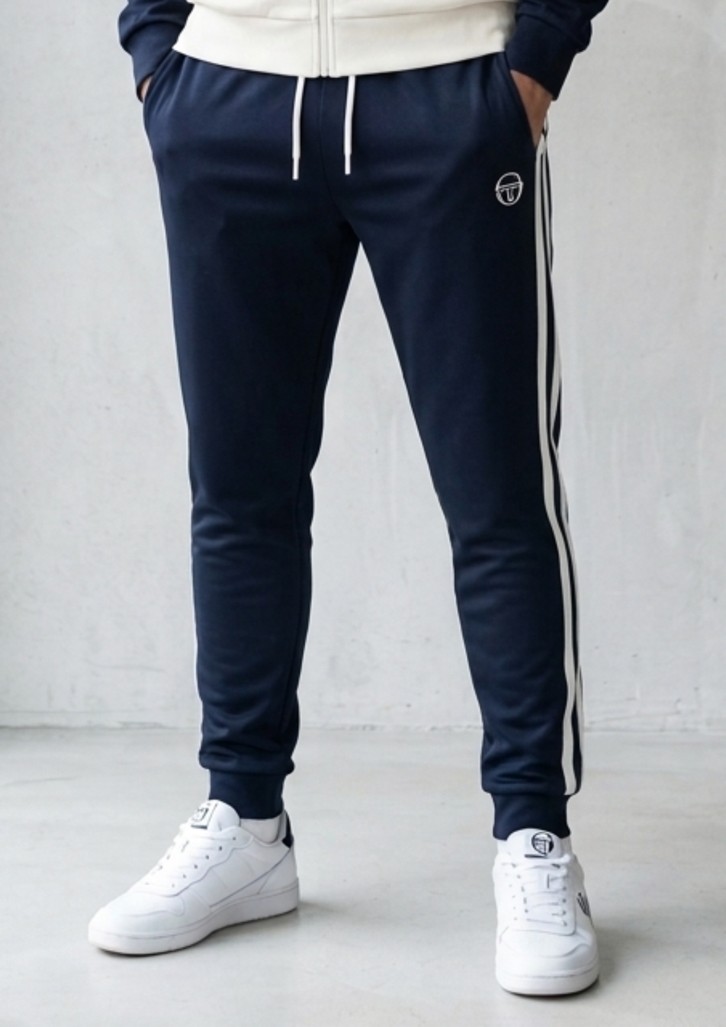 Black Sergio Tacchini New Ghibli track pants with Clique branding, featuring a relaxed fit and elastic waistband.
